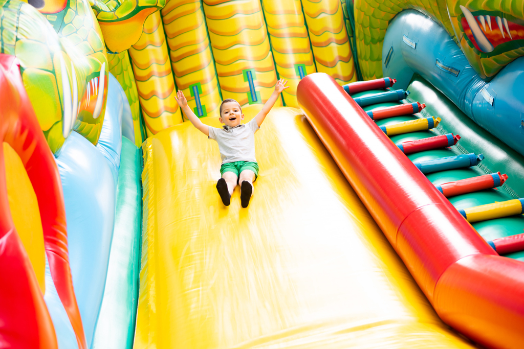 Children sliding down an inflatable slide. Make your event unforgettable with inflatable rides and games in Wilmington, DE.