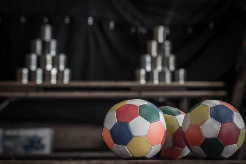 Colorful balls and tin can pyramid setup, perfect for adding fun and interaction at a company picnic or corporate event.