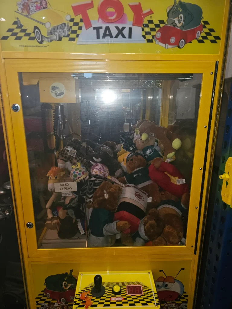 Yellow Toy Taxi prize claw machine filled with plush prizes
