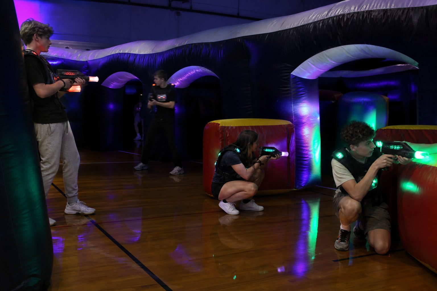Teenagers playing laser tag in an inflatable arena at a Blue Bell after-prom
