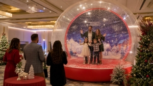 Family inside a giant inflatable snow globe at a Blue Bell holiday party