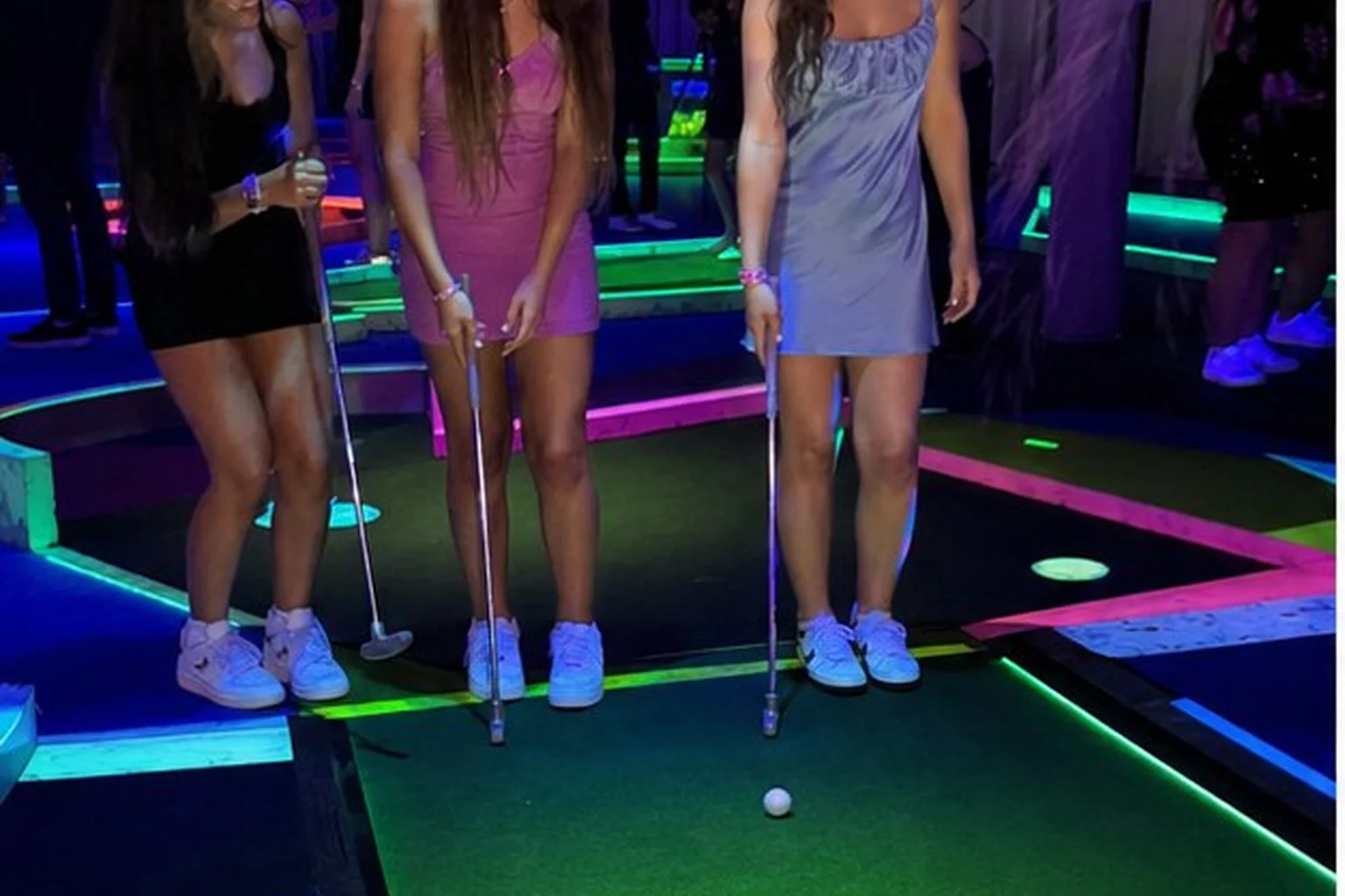Teen guests playing black light mini golf at an indoor Blue Bell party