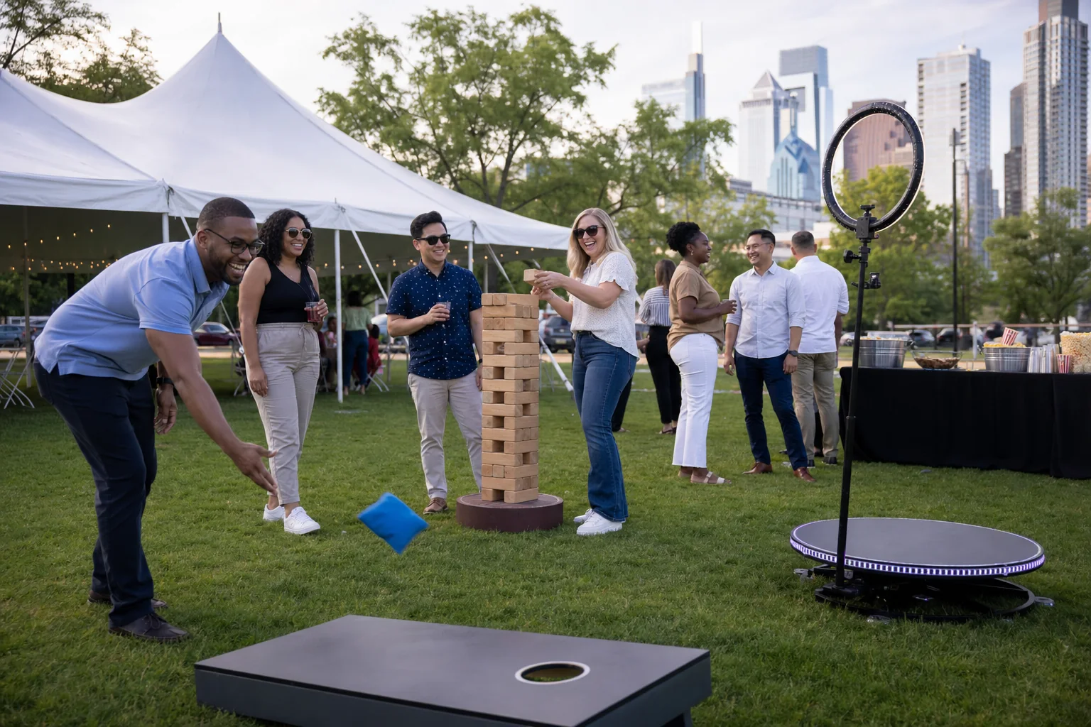 Coworkers playing cornhole and giant games at a Philadelphia company picnic with a 360 photo booth