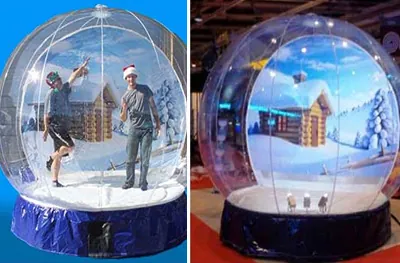 Guests posing inside an inflatable giant snow globe with a winter village backdrop