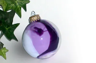 Hand-decorated purple and white glass ornament from an ornament making station